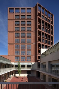 Block of flats with school in brick, concrete and wood
